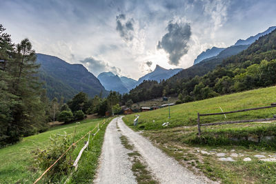 Road amidst green mountains against sky