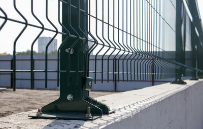 Low angle view of metallic gate against sky