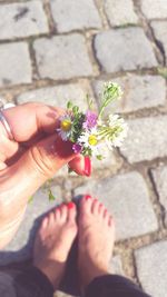 Low section of woman with pink flowers