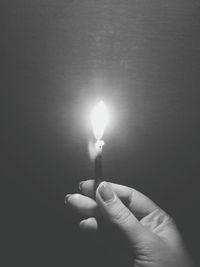 Close-up of hand holding lit candle