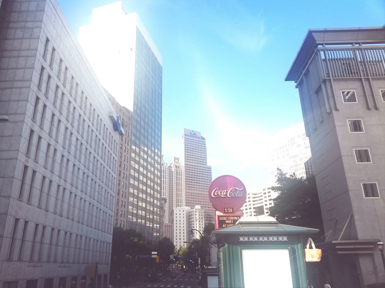 building exterior, architecture, built structure, low angle view, city, sun, sunlight, building, sunbeam, sky, lens flare, day, clear sky, no people, window, outdoors, tower, communication, skyscraper, office building