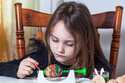 Portrait of girl looking down while sitting on table