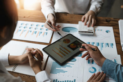 Cropped hands of business colleagues working on table