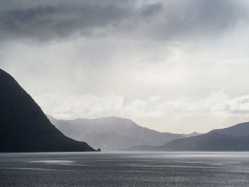 Scenic view of sea and mountains against sky