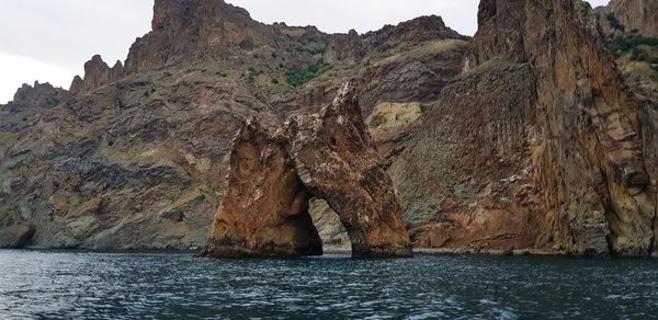 Scenic view of rock formation in sea against sky