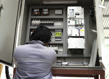 Rear view of man using indoors