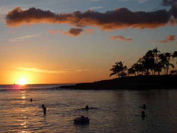 Silhouette man swimming in sea during sunset