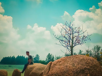 Man looking at view of bare trees against sky