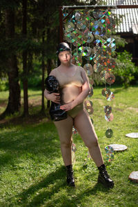 Portrait of young woman in a cap against the background of cd disks holds a mannequin in her hands