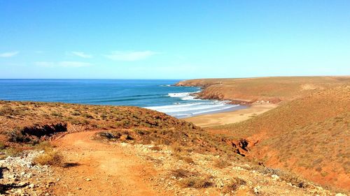 Scenic view of beach against blue sky