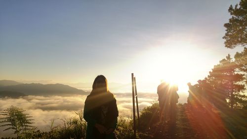 Man standing on mountain against sky during sunset