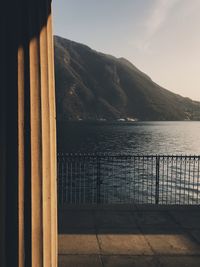 Scenic view of sea by mountains against sky