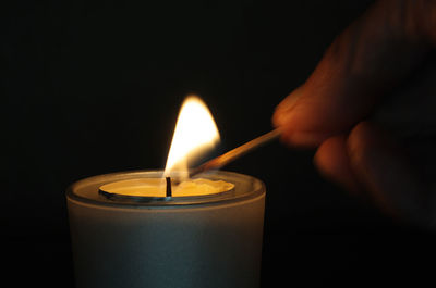 A man lights a candle with a match