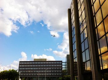 Low angle view of modern building against cloudy sky