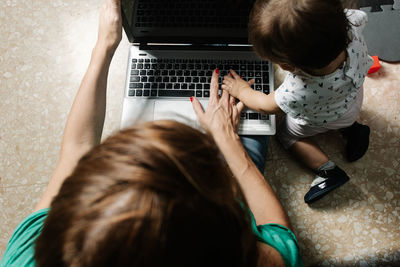 Remote working mother with kid using laptop
