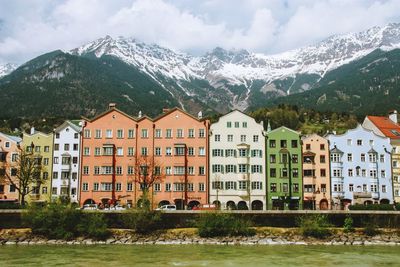 Residential buildings by mountains against sky