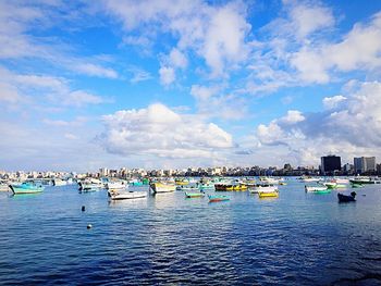 Boats moored in sea against blue sky