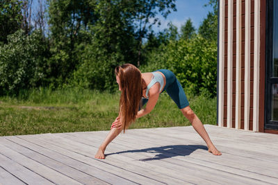 Middle aged woman in sportswear stretching outdoor. warm-up before yoga training in park