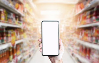 Man holding mobile phone in store