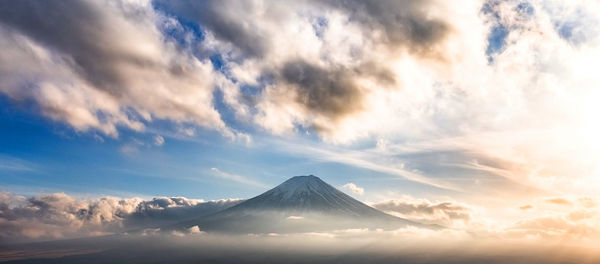 View of snowcapped mountain against cloudy sky