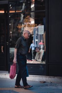 Full length of man standing on footpath in city