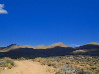 Scenic view of mountains against blue sky