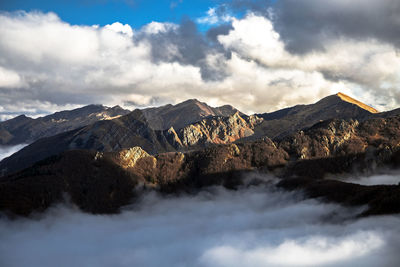 Mountains surrounded by clouds during autumn in appennino tosco emiliano, parma, italy