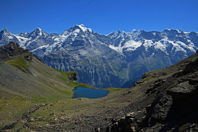 Scenic view of snowcapped mountains against clear blue sky