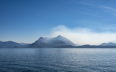 Scenic view of sea and mountains against sky