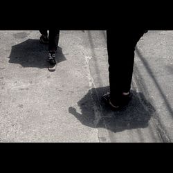 Low section of woman walking on road