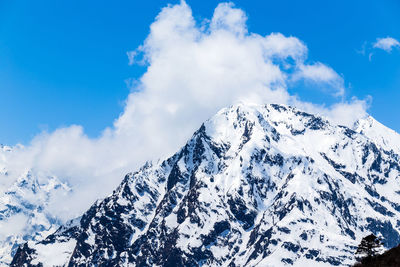 Scenic view of snowcapped mountains against blue sky