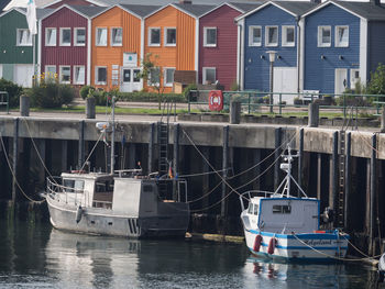 Boats moored in river by buildings