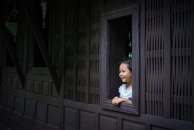 Portrait of smiling girl sitting on man looking away