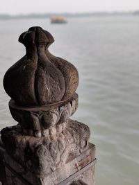 Close-up of stack of statue against sea