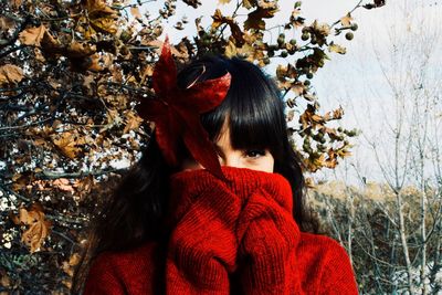 Portrait of woman with red leaves during winter