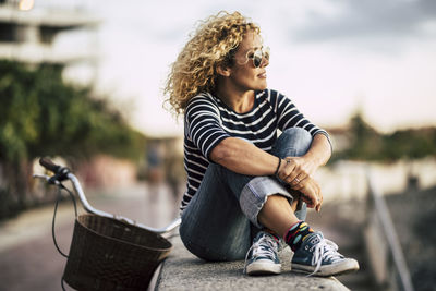 Woman looking away while sitting in city