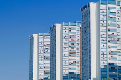Low angle view of buildings against clear blue sky