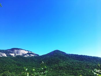 Scenic view of mountains against clear blue sky