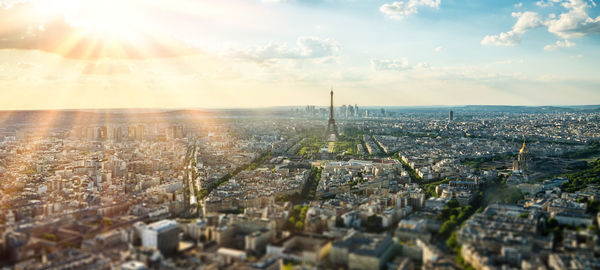 Aerial view of city buildings against cloudy sky