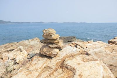 Stack of rocks on beach against clear sky