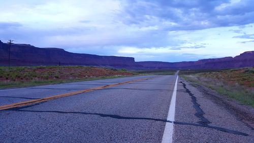 Empty long road leading towards mountain in utah