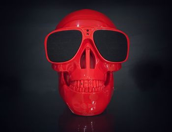 Close-up of red plastic human skull on black background