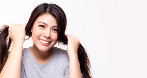 Portrait of a smiling young woman against white background