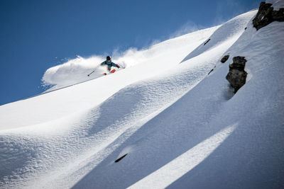 Low angle view of man skiing on snow covered mountain