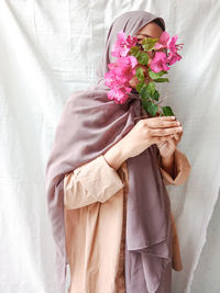 Midsection of woman with bouquet