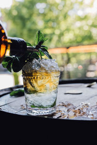 Making a mint julep cocktail with bourbon, fresh mint, crushed ice on whiskey barrel