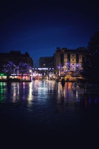 Illuminated cityscape against sky at night