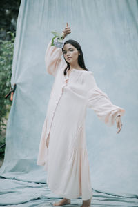 Full length of woman standing against white wall