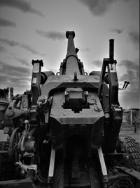 Old machinery against sky during sunset