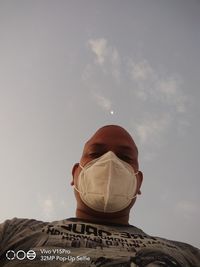 Low angle view of man with umbrella against sky